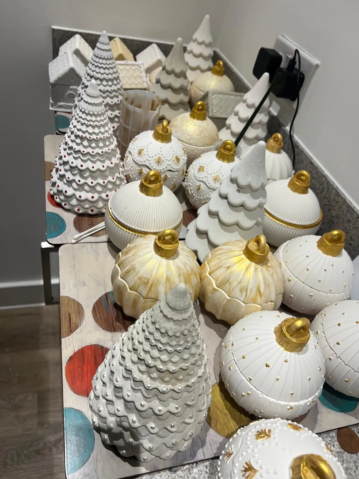 Handmade white and gold ornament candles on the worktable
