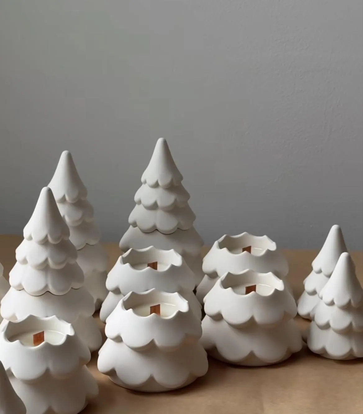 Matte white tree-shaped candles arranged on wood
